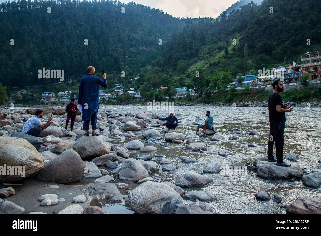 Keran Kupwara, India. 24th Aug, 2023. People are seen filming towards Pakistan Administered Kashmir on the banks of Neelam river or Kishan Ganga that has divided Kashmir into two parts controlled by nuclear rivals India and Pakistan. The river acts as a disputed line of control and flows through a village called Keran from both sides which is located on the northern side of Indian Kashmir's Border district Kupwara some 150kms from Srinagar and 93kms from Muzaffarabad, in the Pakistan side of Kashmir. (Photo by Faisal Bashir/SOPA Images/Sipa USA) Credit: Sipa USA/Alamy Live News Stock Photo