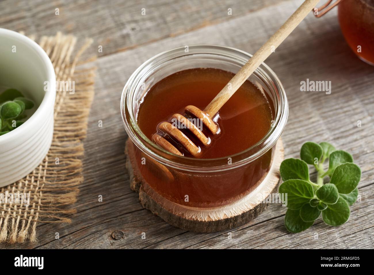 Coleus amboinicus syrup in a glass jar with a honey dipper Stock Photo