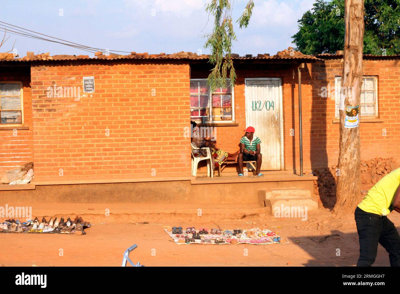 A woman and man are seated outside their home where she has set up a ...