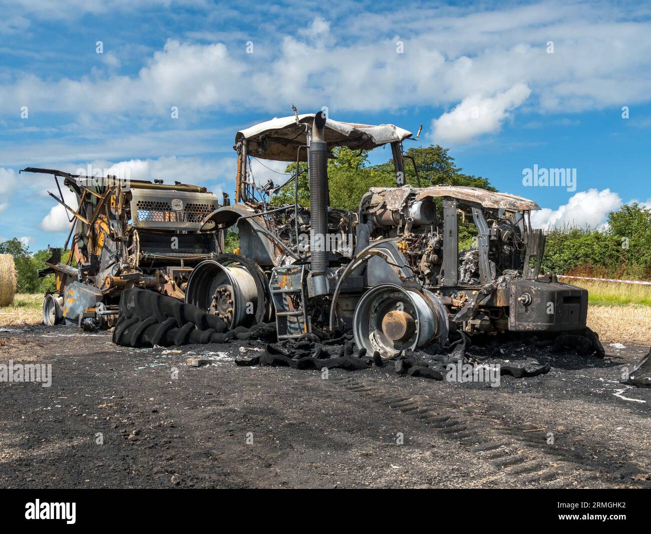 Burnt out remains of farm tractor in a field following a fire which totally destroyed the tractor and baler, Leicestershire, England, UK Stock Photo