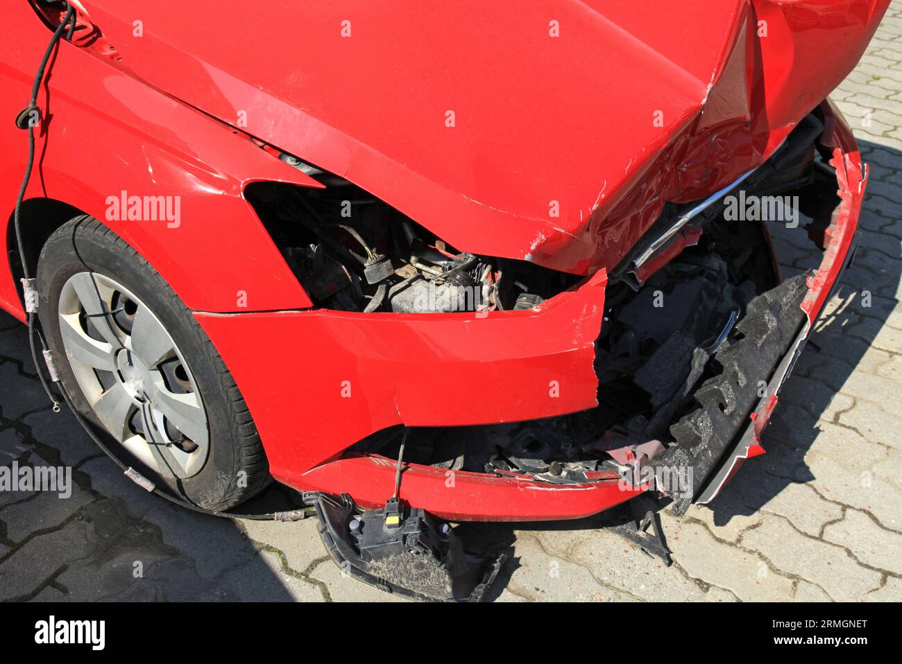 Crashed car of red color. Side view of the wrecked vehicle. The car
