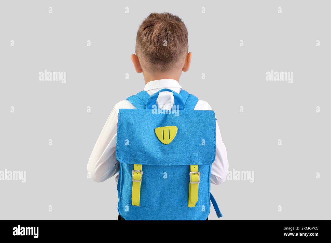 Little schoolboy with blue backpack on grey background, back view Stock ...