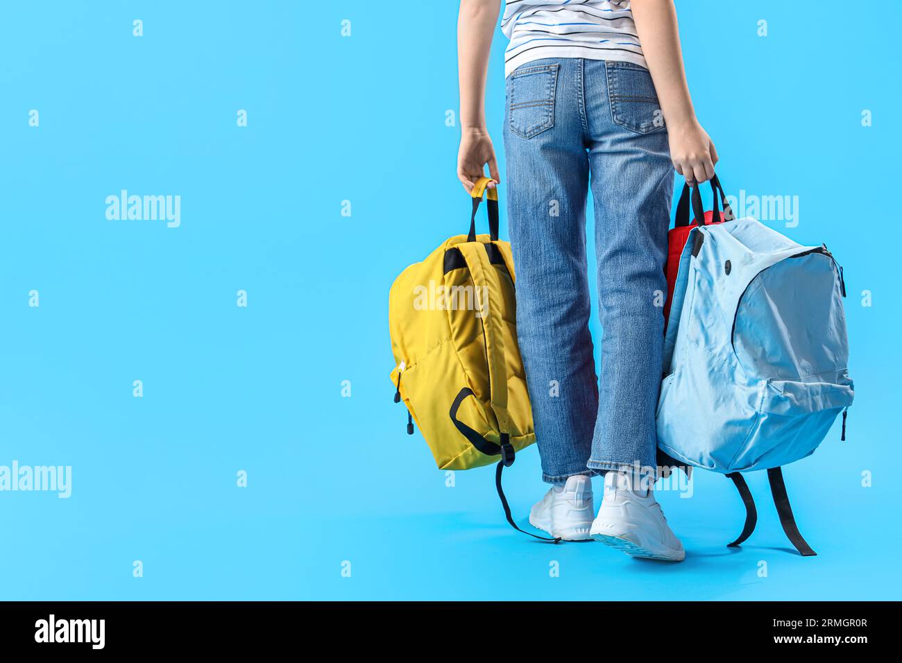 Little schoolboy with backpacks on blue background, back view Stock ...