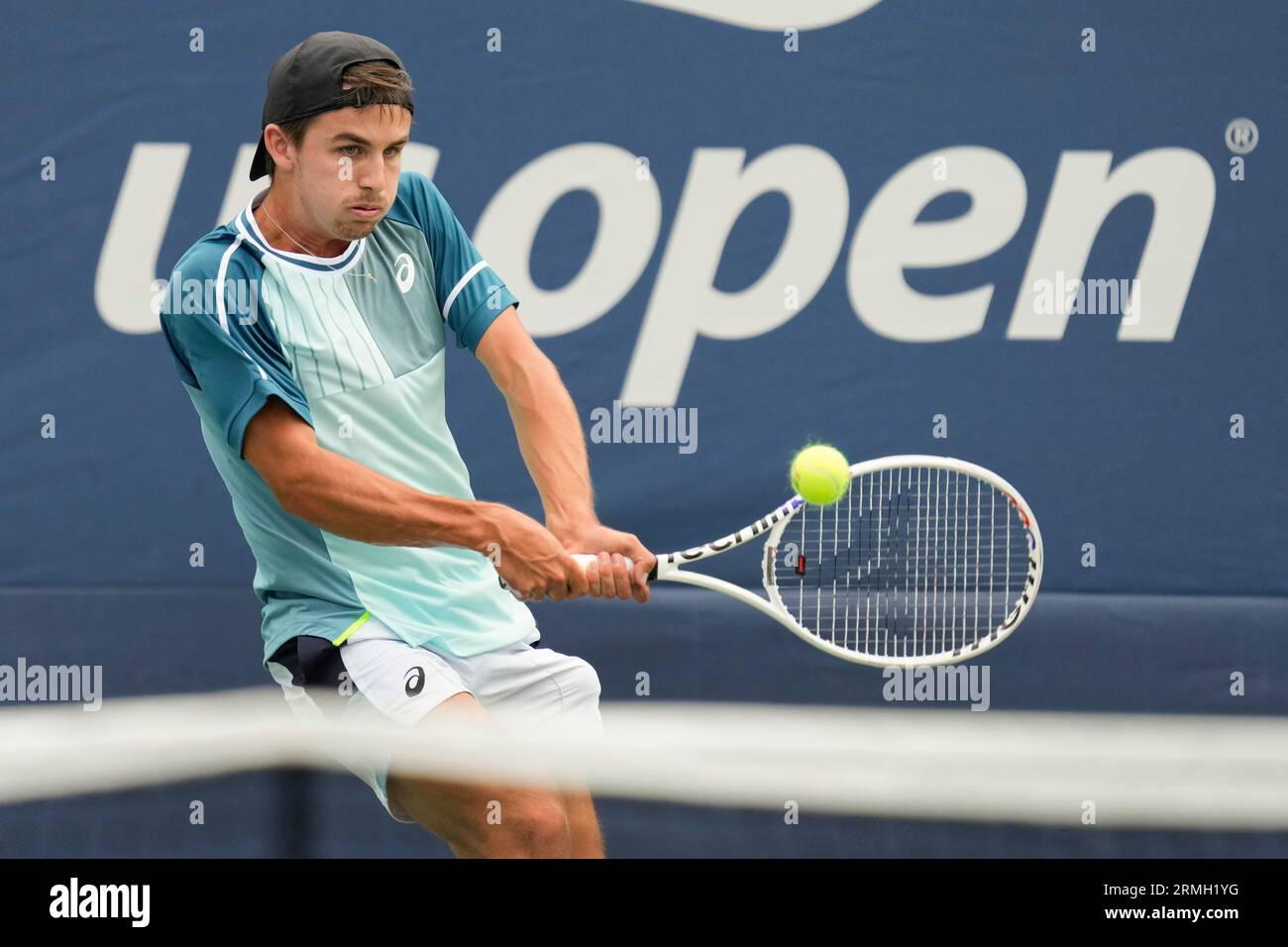Zachary Svajda, of the United States, returns a shot to Francisco Cerundolo, of Argentina, during the first round of the U.S. Open tennis championships, Monday, Aug