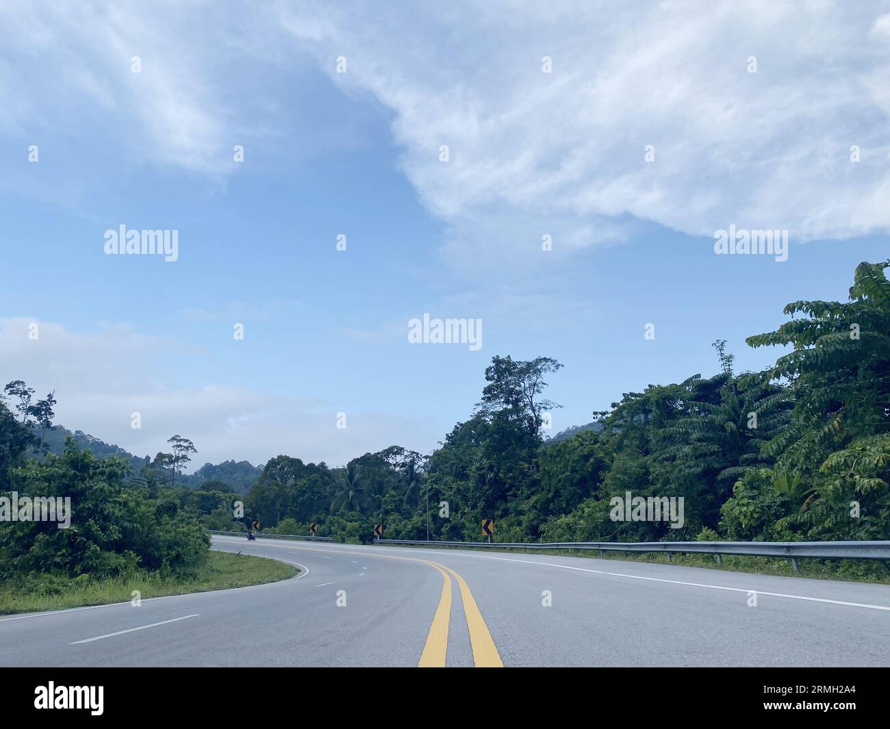 road asphalt in the forest nature countryside of Thailand, road environment high voltage electric pol. tree jungle travel green landscape. road way. Stock Photo
