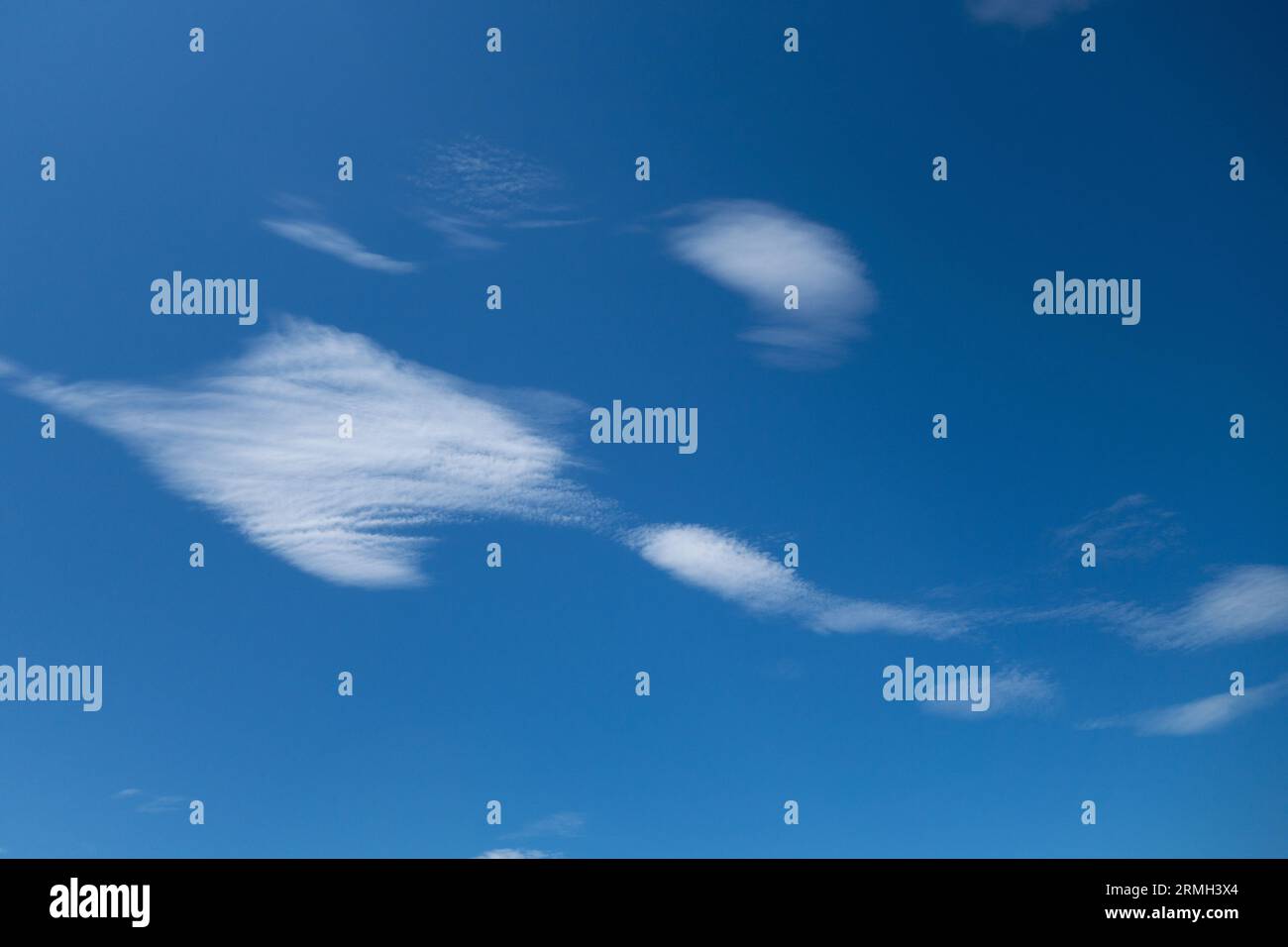Cute wispy clouds in a blue sky. Stock Photo