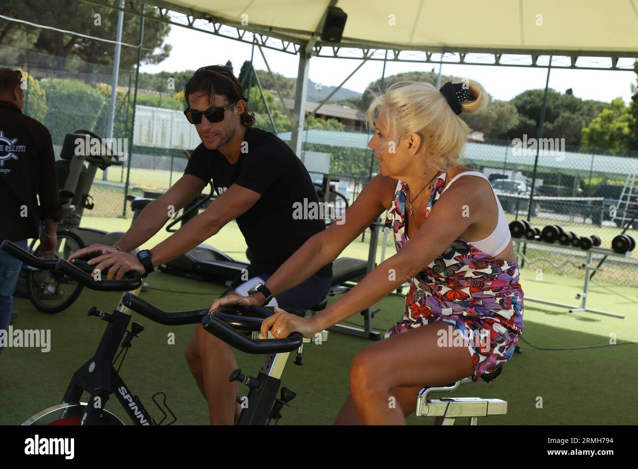 Maria Teresa Ruta Italian Famous Italian television presenter, journalist and writer, cycling on a cyclette with personal trainer for a tv show Stock Photo