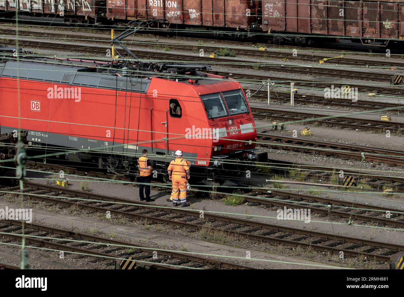 Hagen, Germany. 28th Aug, 2023. Bahn workers talk to a train driver on