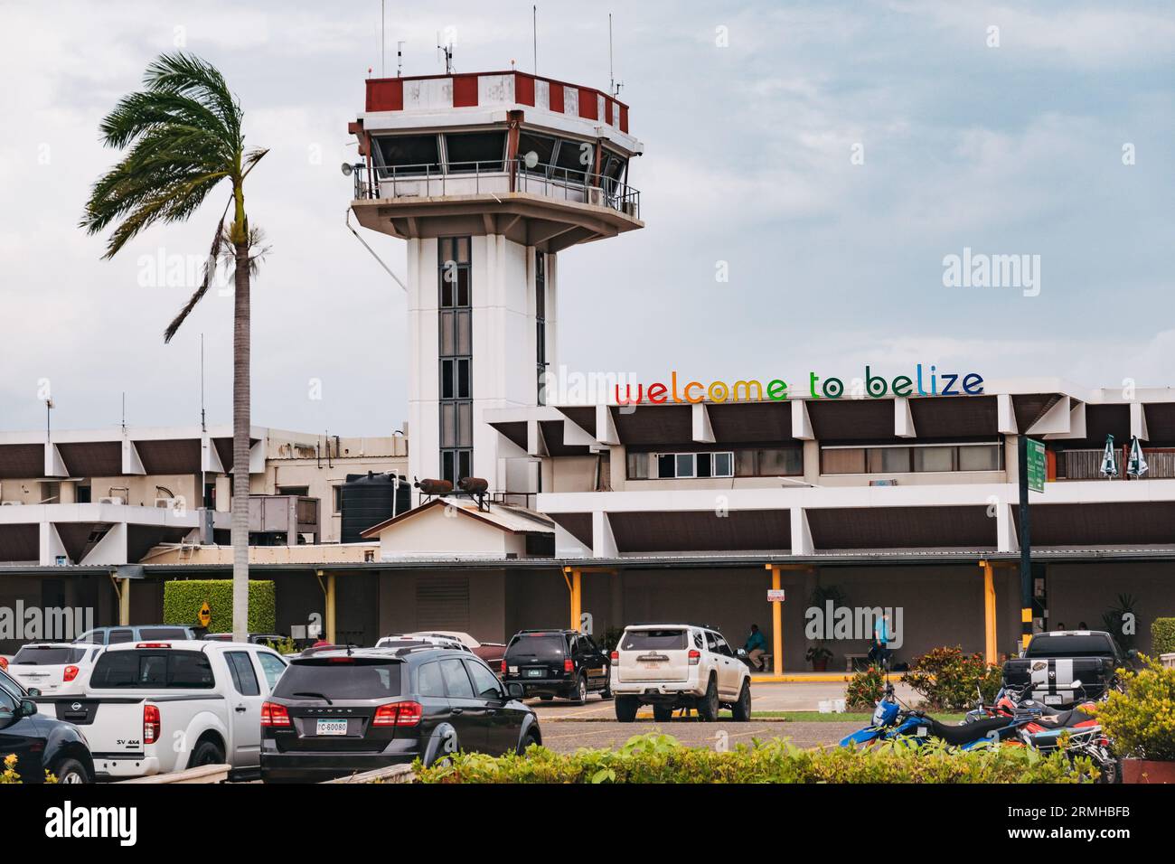 The control tower and airport building at Philip S.W. Goldson International Airport, Belize City. A sign on the terminal reads 'welcome to Belize' Stock Photo