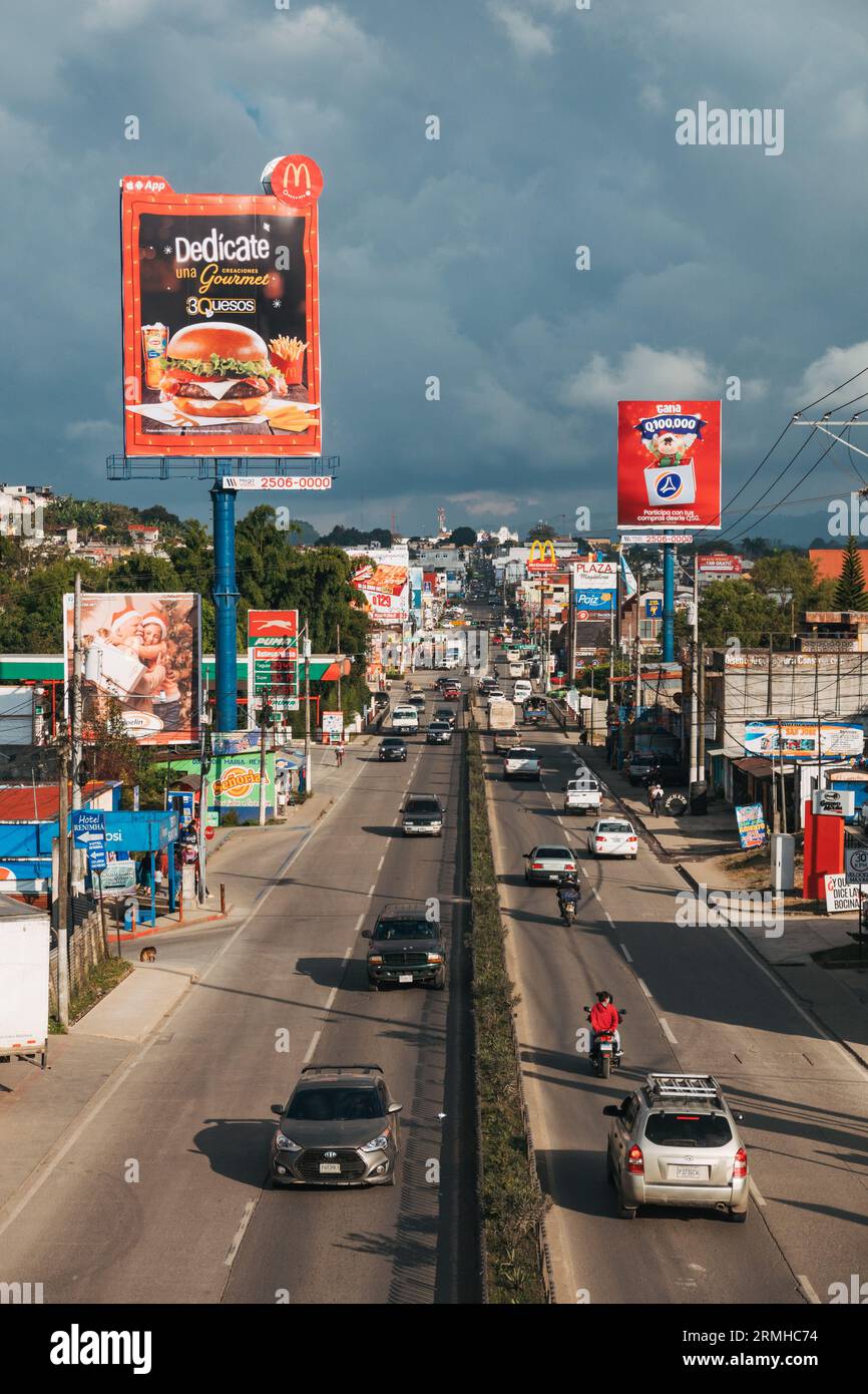 Fast food chains and billboards line the highway of National Route 5 as it passes through the city of Cobán, Central Guatemala Stock Photo