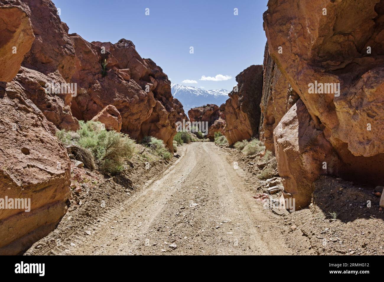 single lane Chidago Canyon Road in winds between volcanic tuff cliffs in the desert of  Eastern California Stock Photo