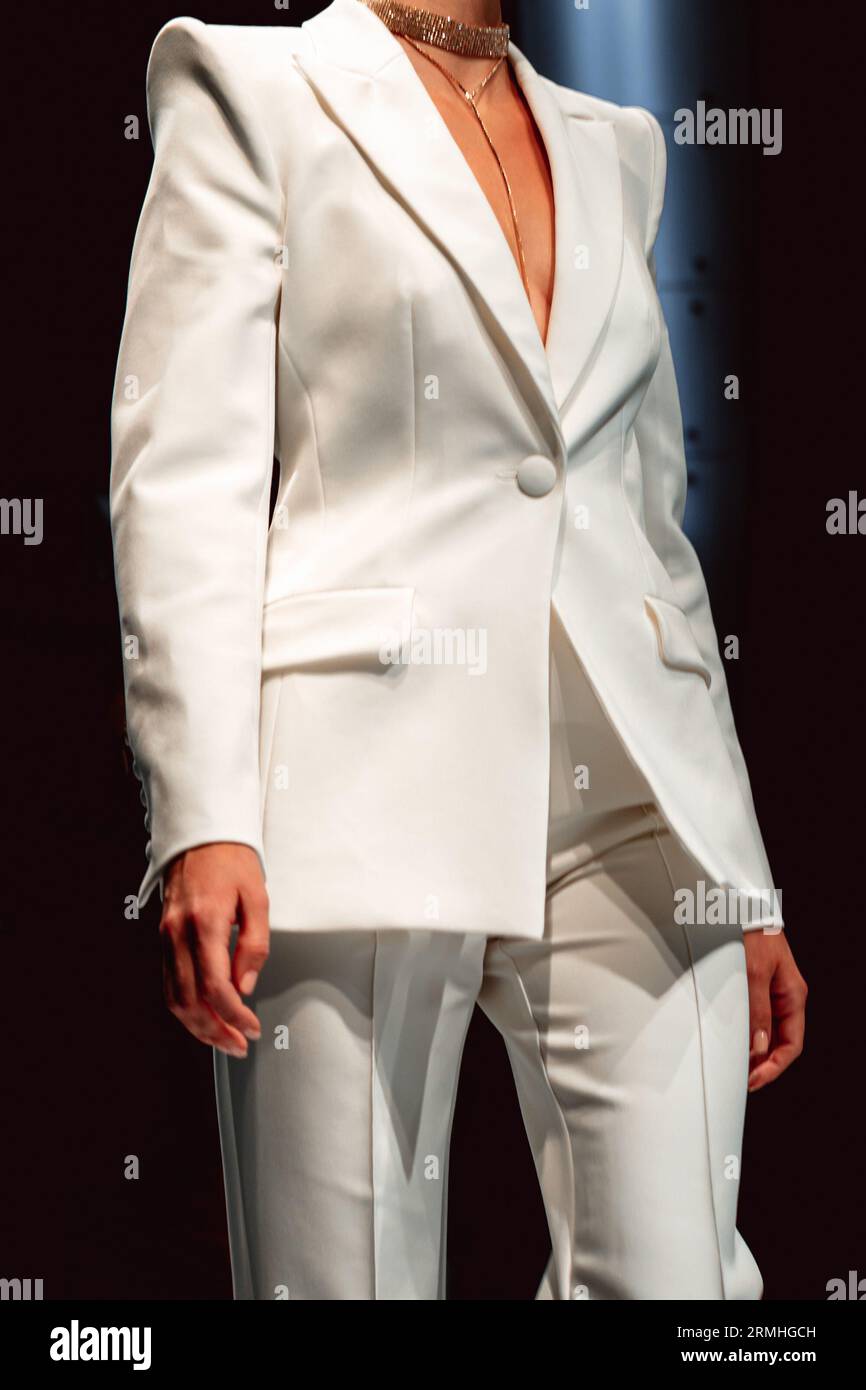 Fashionable details of classy white pants and jacket on a female figure. Designer collection clothes. Catwalk Fashion Week Stock Photo