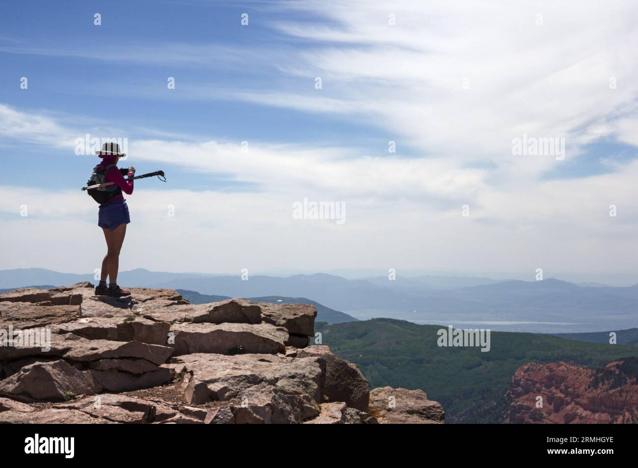 woman dayhiker taking a cell phone photo at an overlook on the summit of Brian Head Mountain in Utah Stock Photo