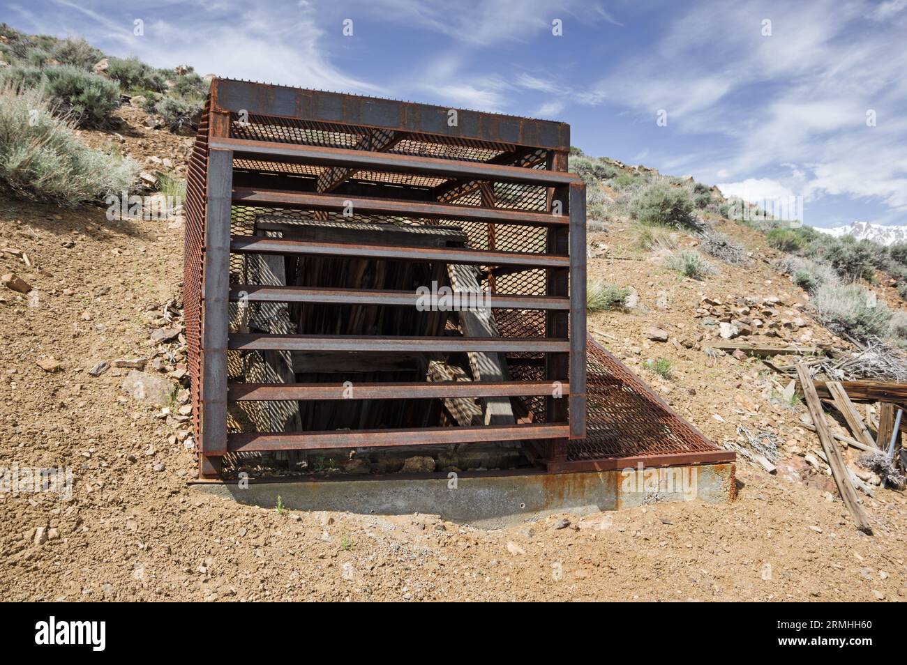 old tungsten mine shaft covered with steel cage to prevent entrance Stock Photo