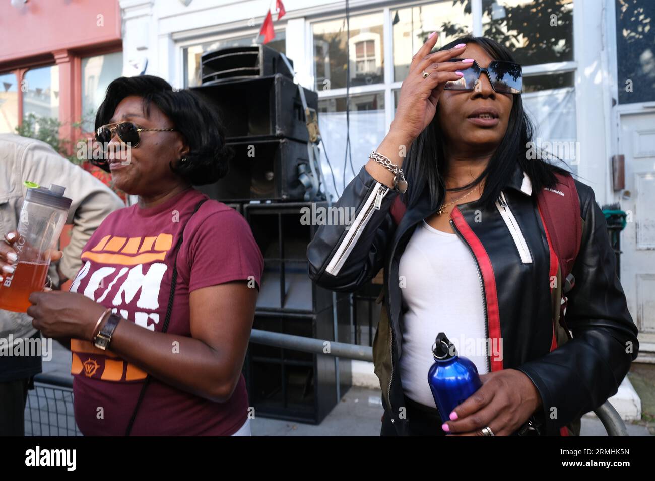 Two women enjoy music from a sound system at the Notting Hill Carnival on Bank Holiday Monday in London. 28/08/2023 Stock Photo