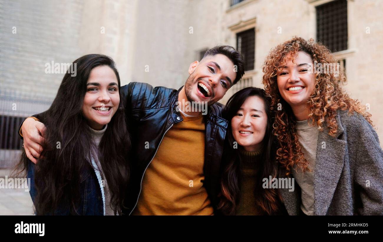 Diverse group of people having fun together outside - Happy friends of different ethnicity looking at camera - Focus on gay non-binary person Stock Photo