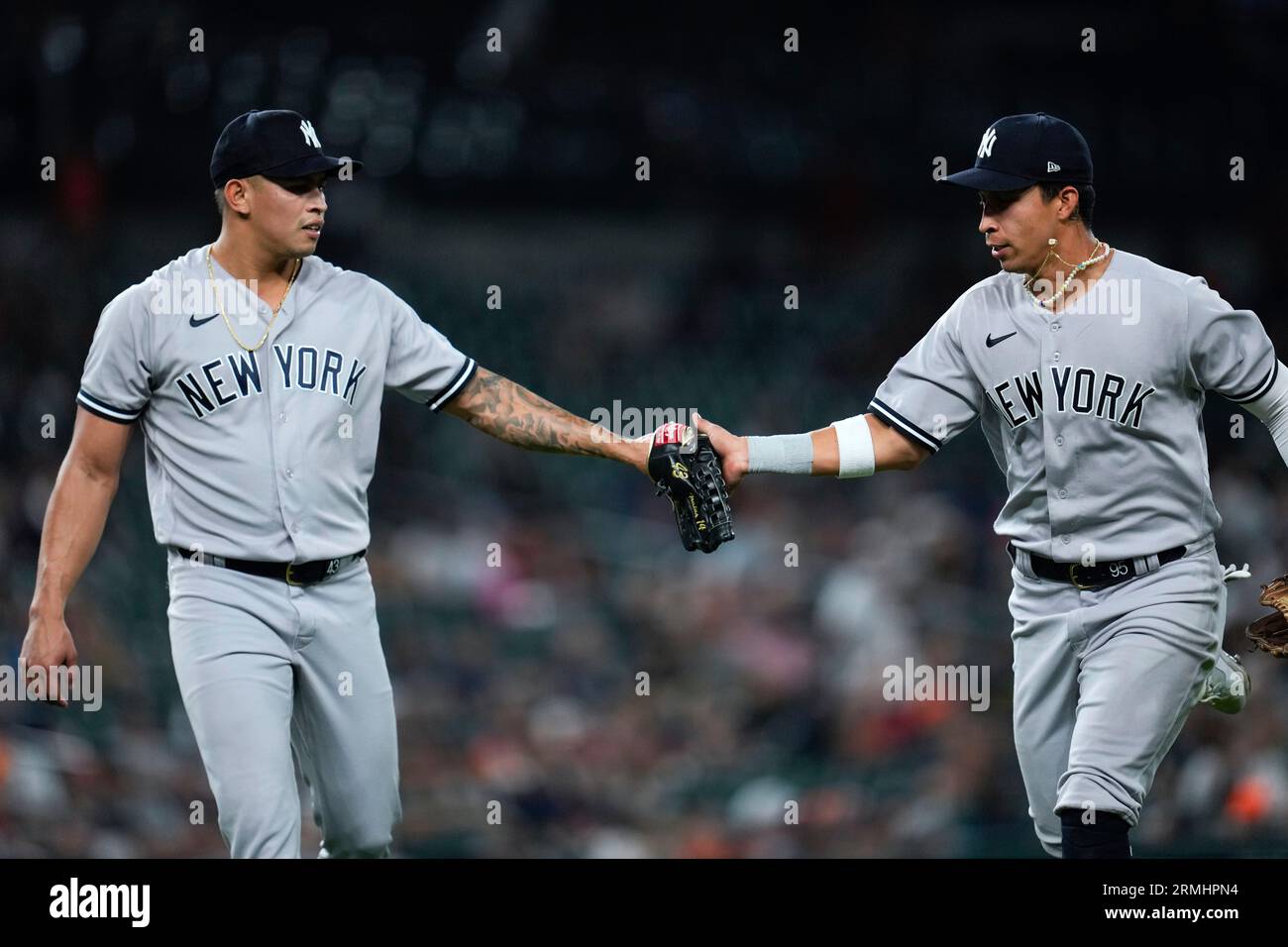 New York Yankees relief pitcher Jonathan Loaisiga, left, congratulates  third baseman Oswaldo Cabrera, right, on his catch of a Detroit Tigers'  Riley Greene line drive in the eighth inning of a baseball