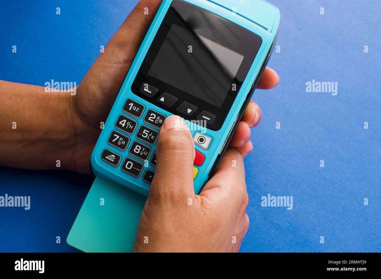 Closeup of hands holding a modern credit card payment device, Contactless technology facilitating fast and secure transactions. Stock Photo