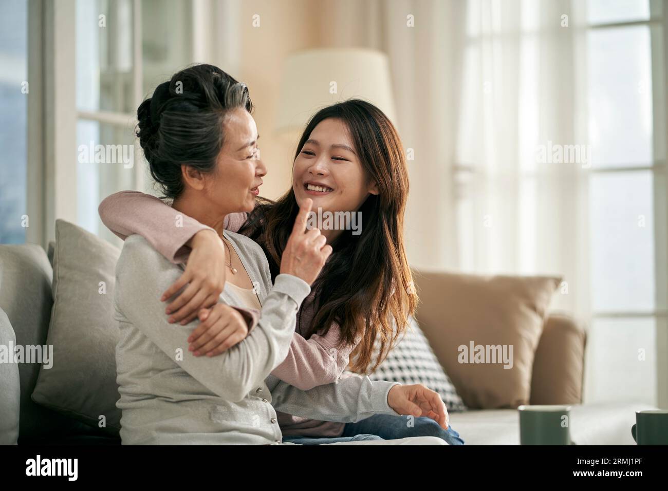 happy senior asian mother and adult daughter having a good time at home Stock Photo