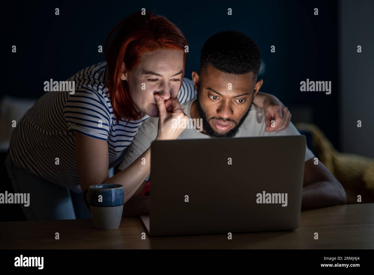 Multiracial man woman family looking at laptop screen buying online choosing goods in marketplace. Stock Photo