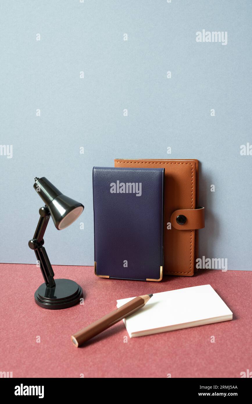 Study and workspace. Notebook, lamp, colored pencil, memo pad on red