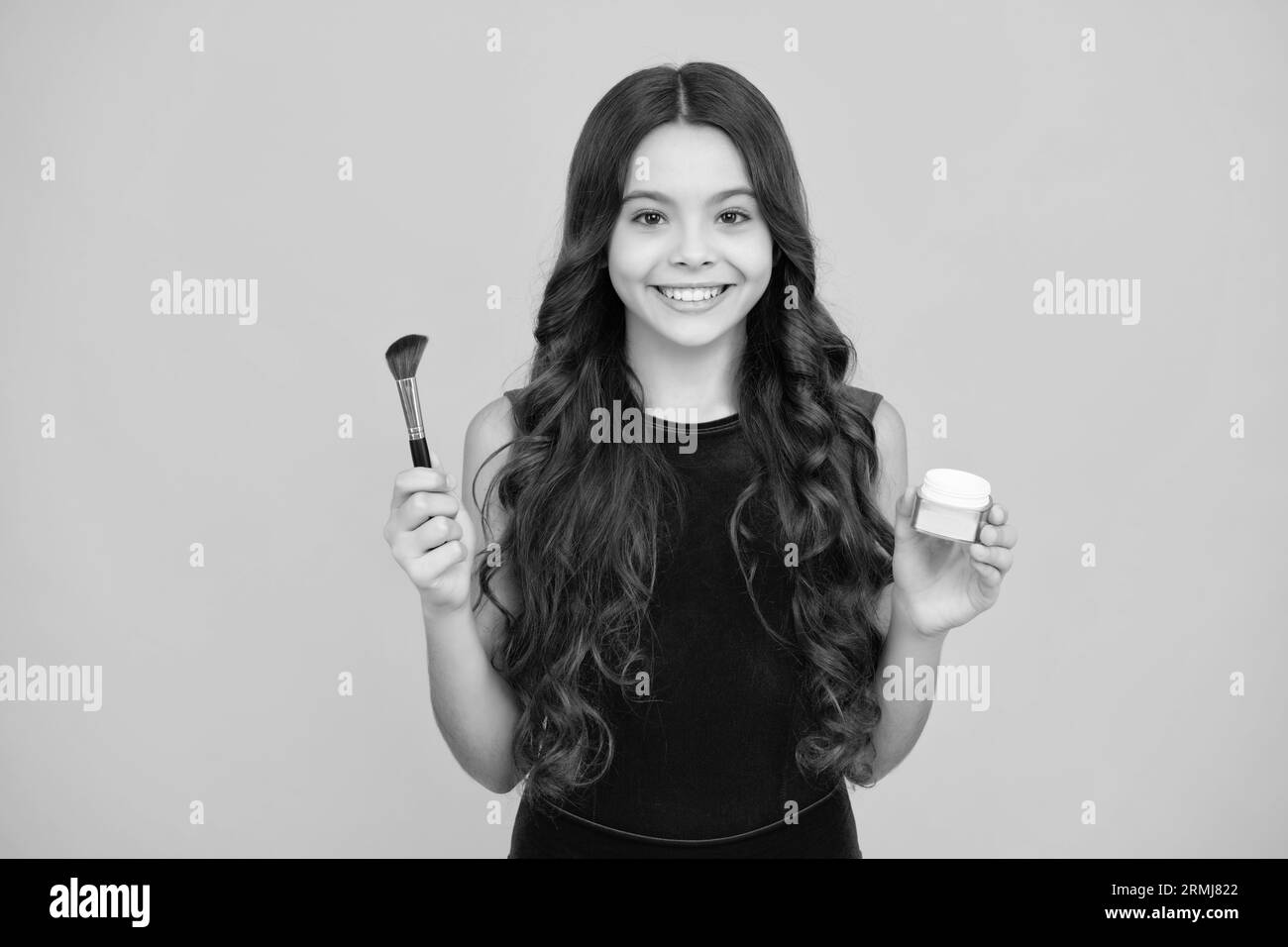 Child girl 12, 13, 14 years old making beauty make up with powder and brush. Beautiful teenager