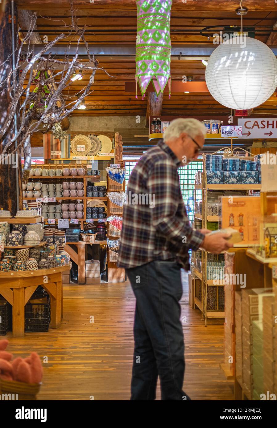 Elderly man at supermarket. Shoppers at grocery store defocused 