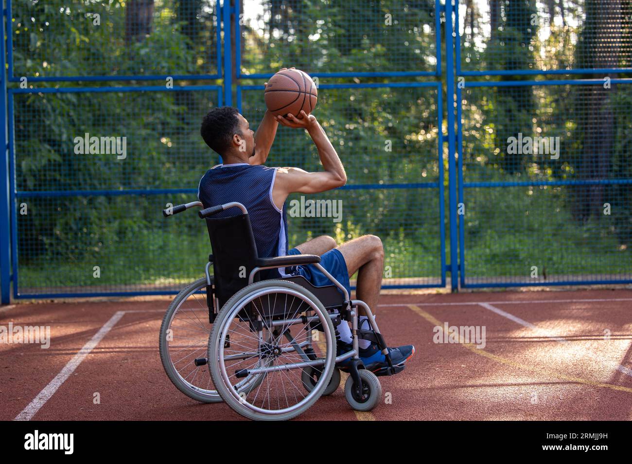 Wheelchair basketball payer dribbling ball like professional, ready to shoot and score goal