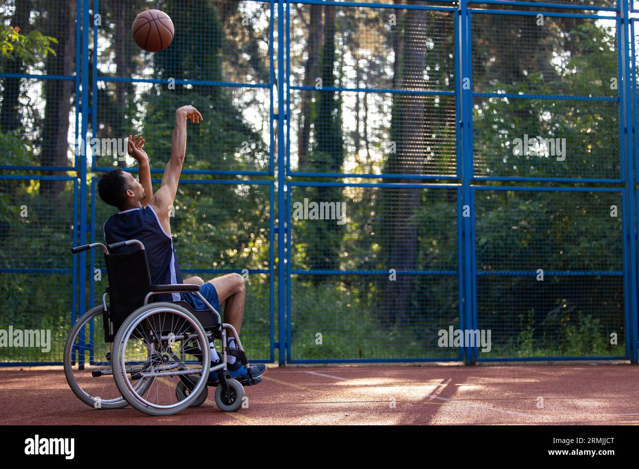 Wheelchair basketball payer dribbling ball like professional, ready to shoot and score goal