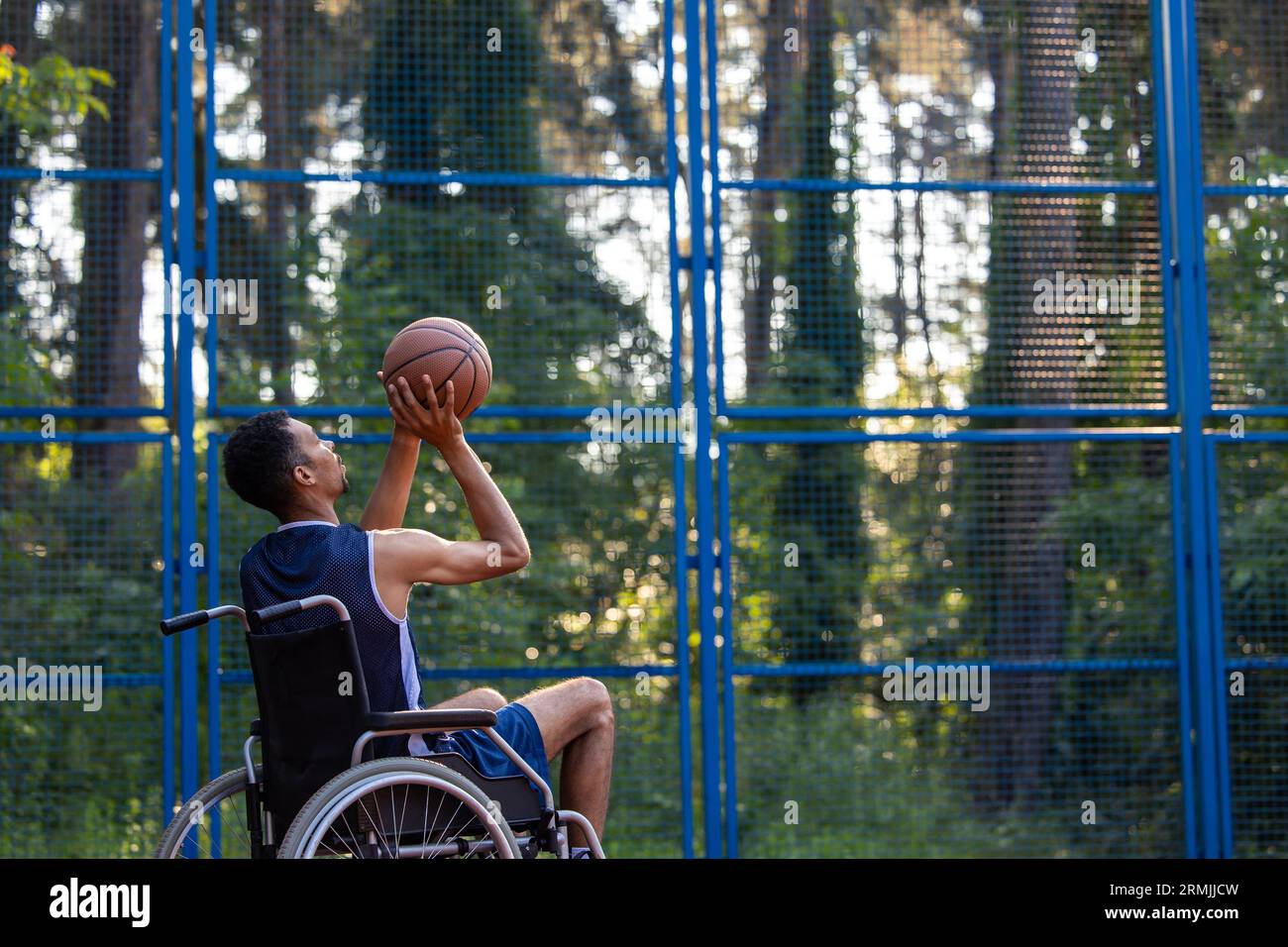 Wheelchair basketball payer dribbling ball like professional, ready to shoot and score goal