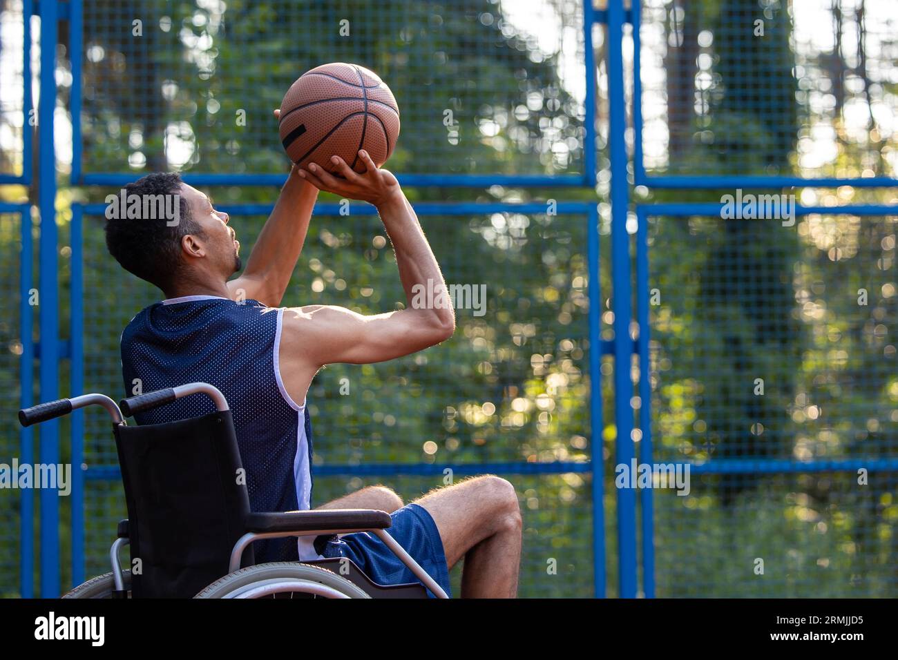 Wheelchair basketball payer dribbling ball like professional, ready to