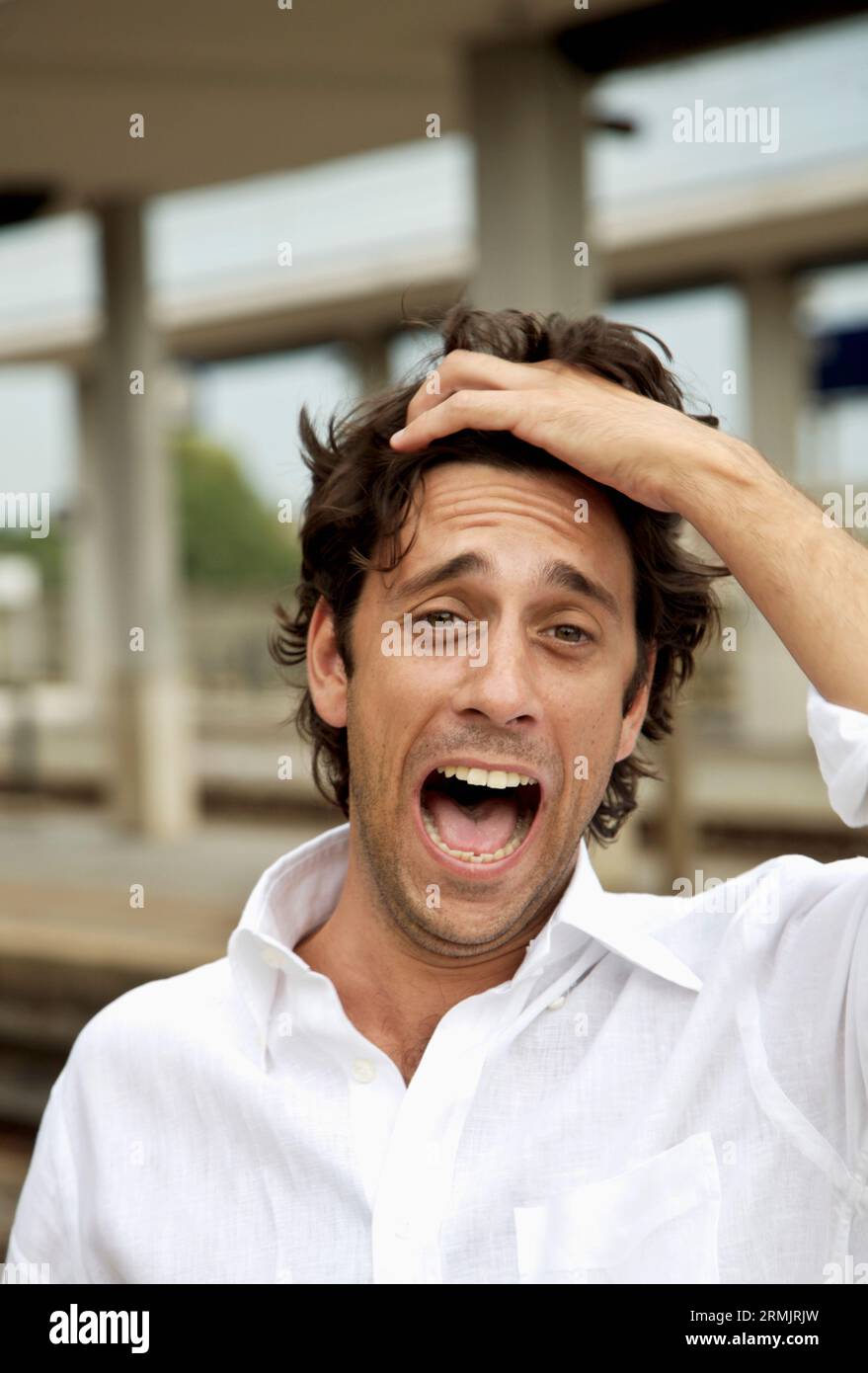 Laughing young man at station pulling hair back Stock Photo Alamy