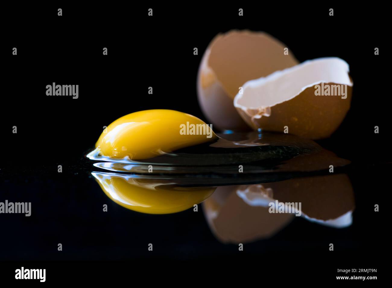 Broken egg on black background Stock Photo - Alamy
