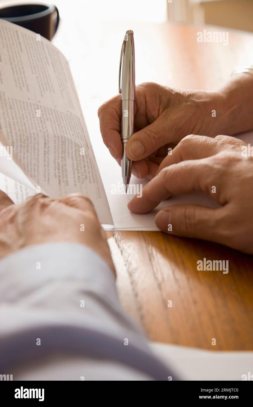 Close up of man and woman hands signing documents Stock Photo