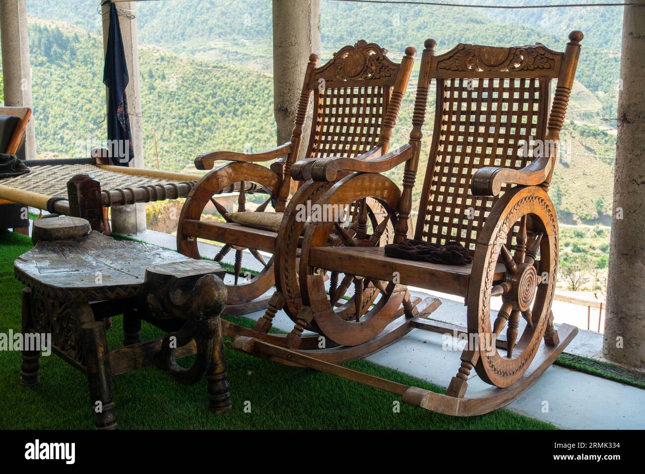 Vintage wooden rocking chairs on rural Uttarakhand balcony. Serene countryside ambiance, India Stock Photo