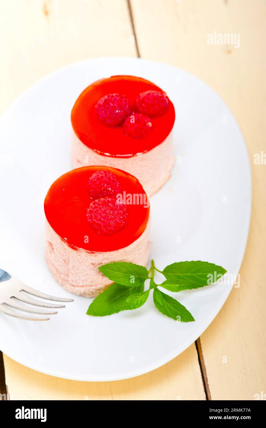 Fresh raspberry cake mousse dessert round shape with mint leaves Stock Photo