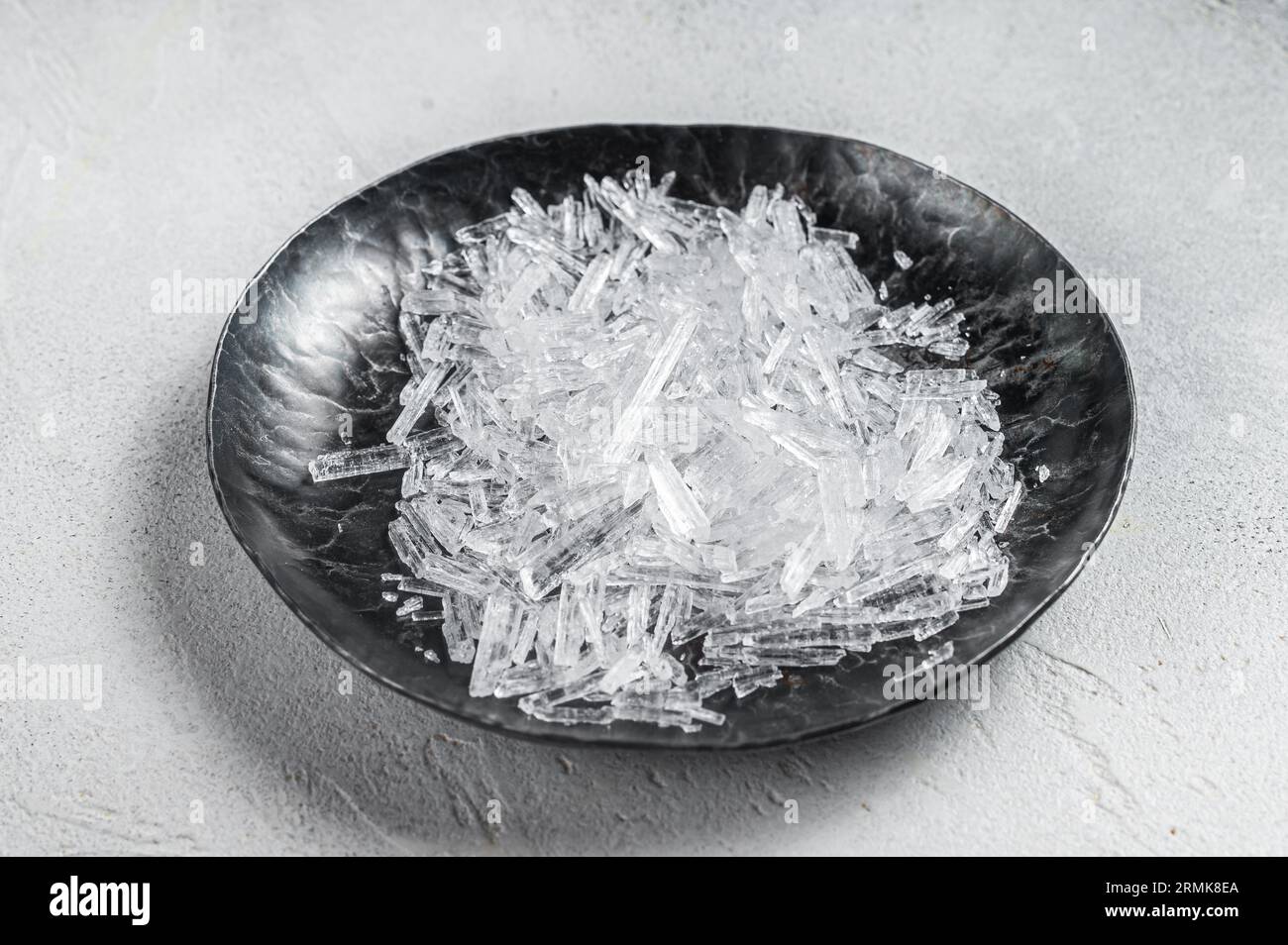 Menthol Crystals in a steel small plate. White background. Top view. Copy space. Stock Photo