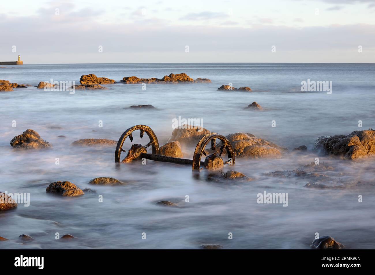 Old Chaldron Wagon Wheels on the Chemical Beach with Seaham Harbour Lighthouse beyond, Durham Heritage Coast, Seaham, County Durham, UK Stock Photo