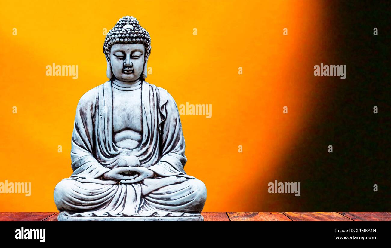 A closeup of a Buddha statue in a meditative pose, illuminated by a
