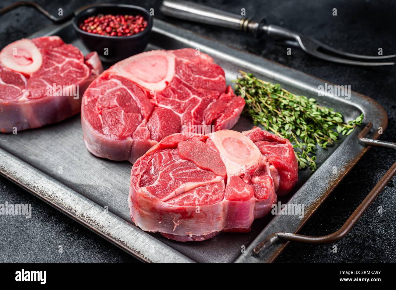 Fresh Raw Osso buco Veal steak, cross cut veal shank Ossobuco. Black background. Top view. Stock Photo