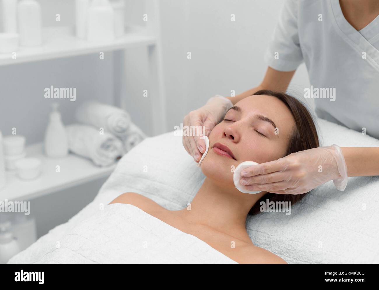 Beautician with female client salon face care routine Stock Photo