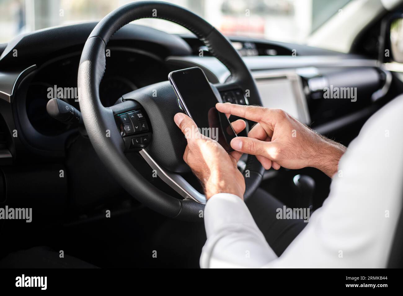 Close up man steer wheel checking phone Stock Photo Alamy