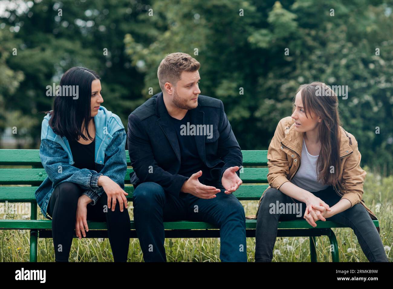 Conflicting people sitting bench talking Stock Photo