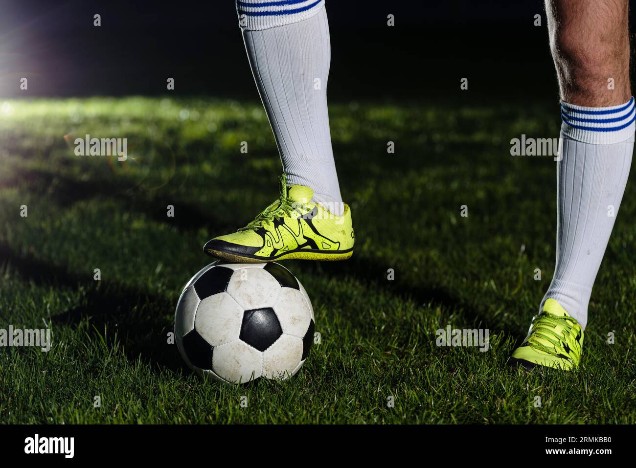 Crop legs stepping soccer ball Stock Photo