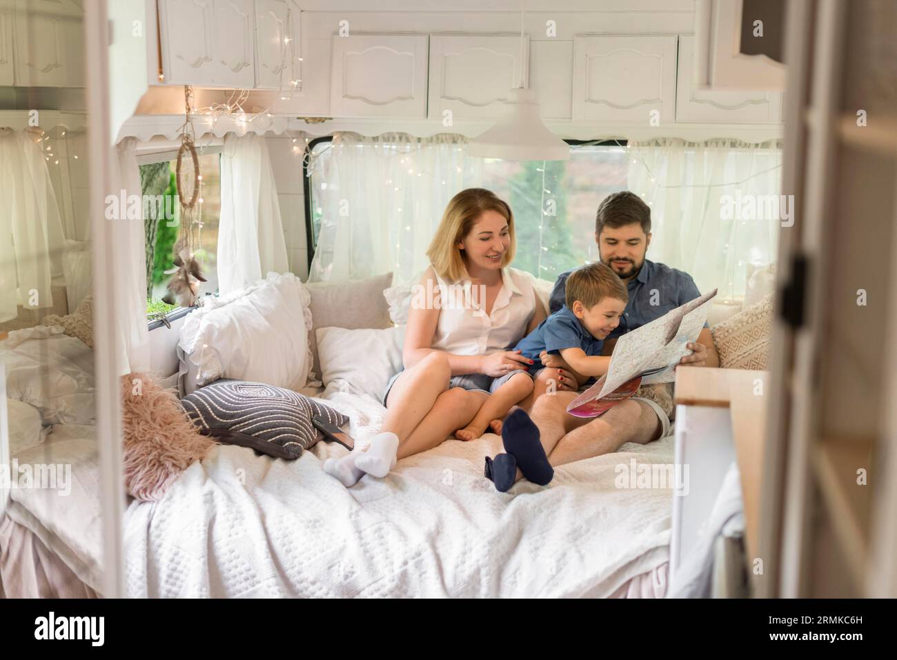 Long shot family looking through map caravan Stock Photo
