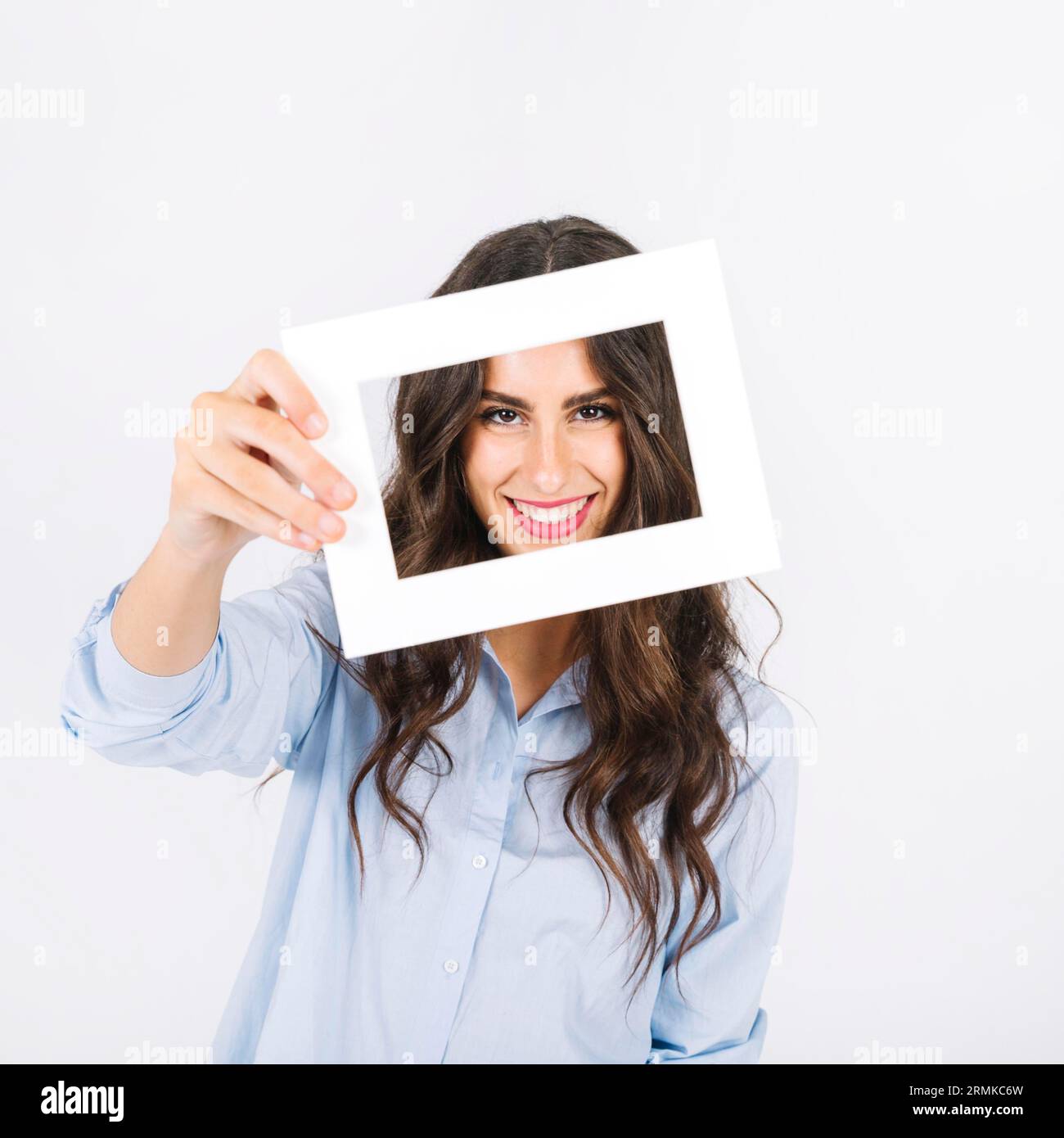 Joyful woman holding frame front face Stock Photo