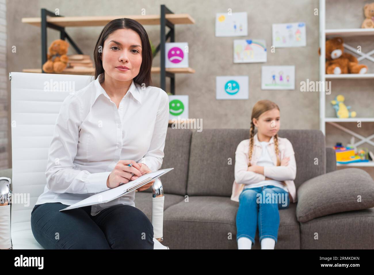 Young female psychologist sitting chair with clipboard pen sitting