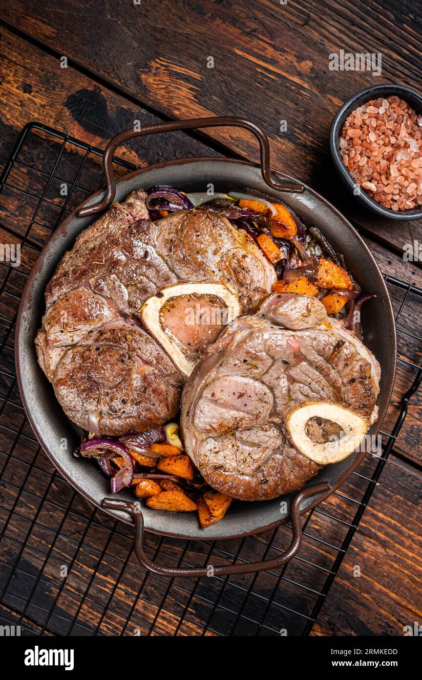 Veal shank stew Osso Buco, italian ossobuco meat steak. Wooden background. Top view. Stock Photo
