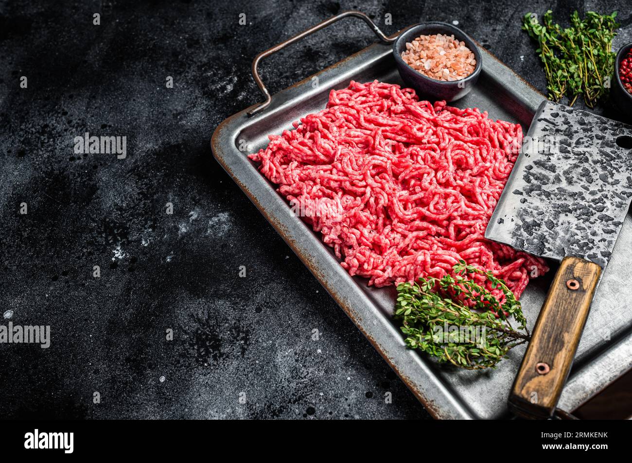 Raw Forcemeat , Mince Ground beef and pork in a kitchen tray. Black background. Top view. Copy space. Stock Photo