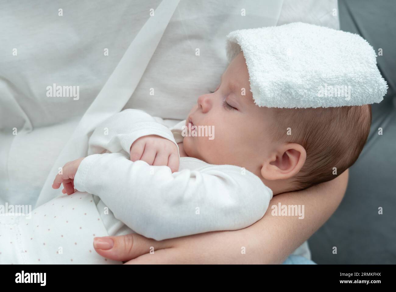Mother applies cooling method to newborn, Concept of using wet towel